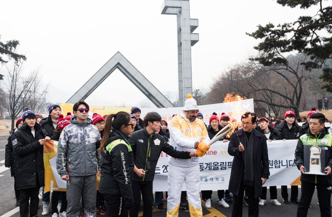 Professor Lee Kyung Soo is lighting the torch on behalf of the Seoul National University